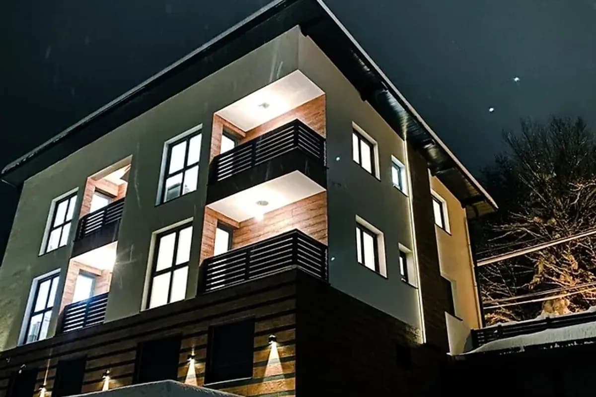 Apartmani Berg multi-level apartment building in Pale with lit balconies at night