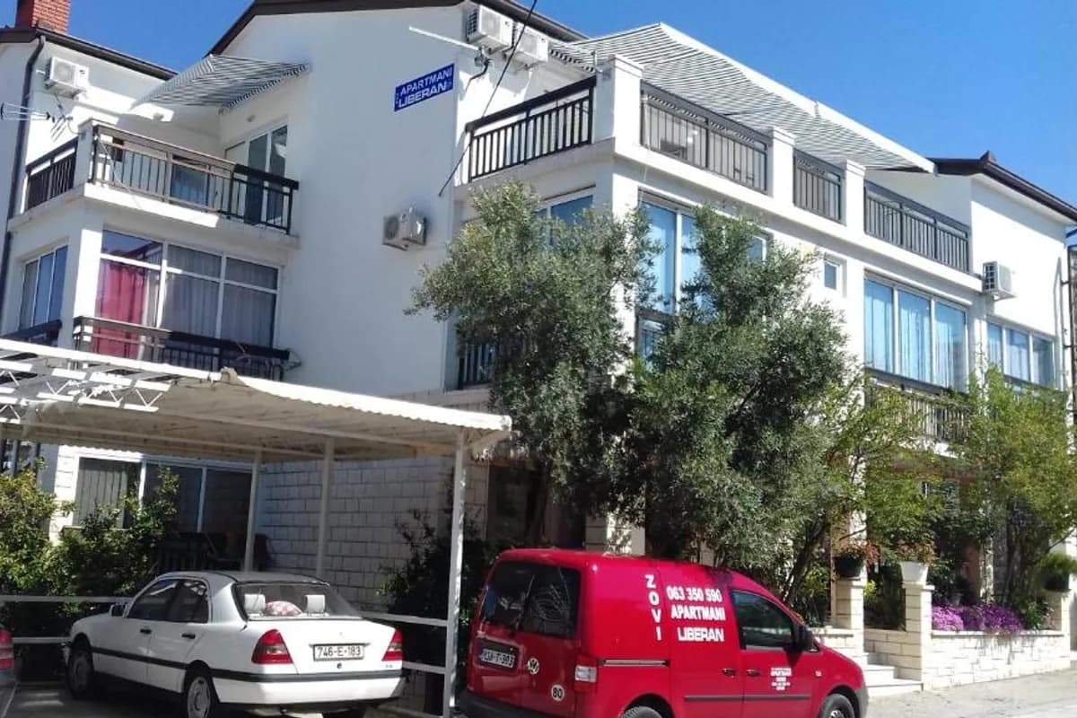 Apartmani Liberan Neum multi-storey apartment building with balconies and its blue APARTMANI LIBERAN sign