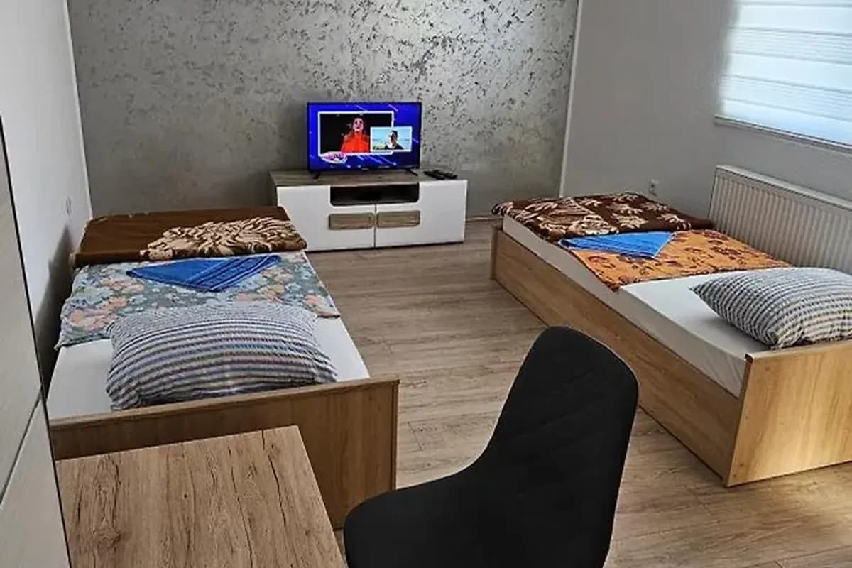 Apartmani Roki Tuzla guest apartment room with two wooden twin beds and a television