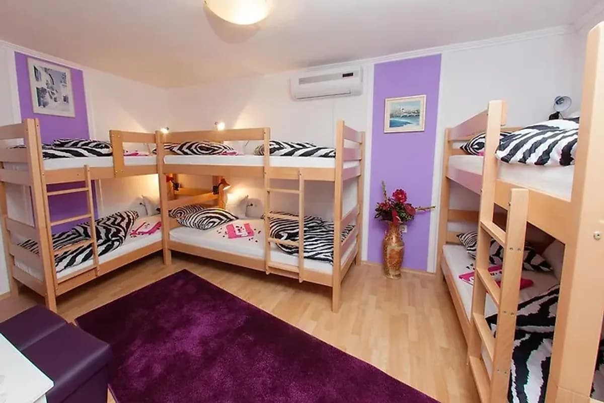 Hostel Mirror Mostar dormitory with wooden bunk beds and purple accent walls