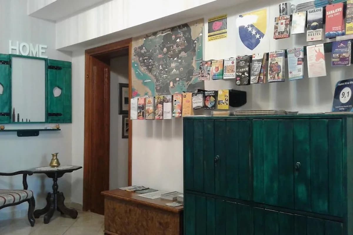 Hostel Nina Mostar reception with teal front counter and wall displays of travel information