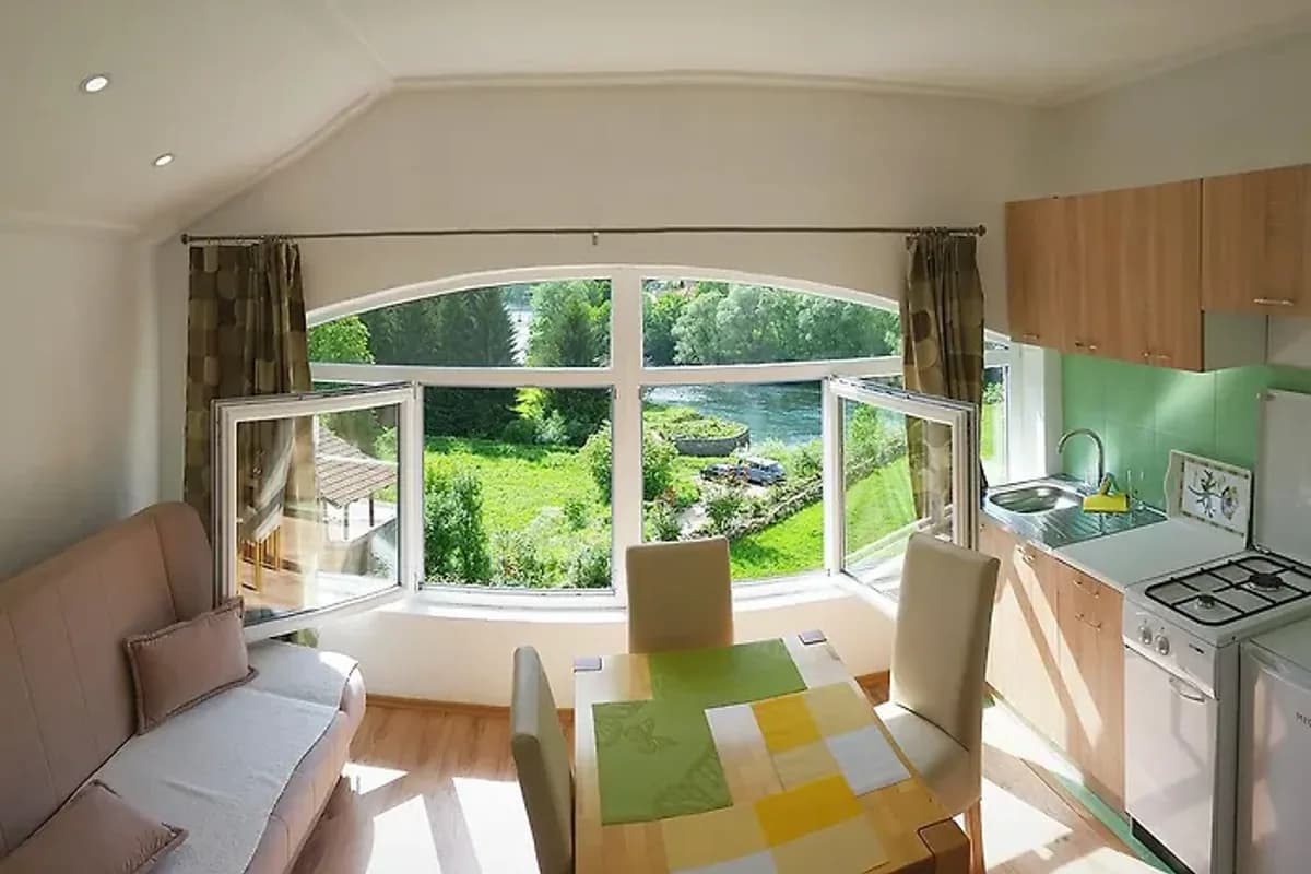 Unaqua Apartments open kitchen and dining area overlooking green surroundings in Kulen Vakuf