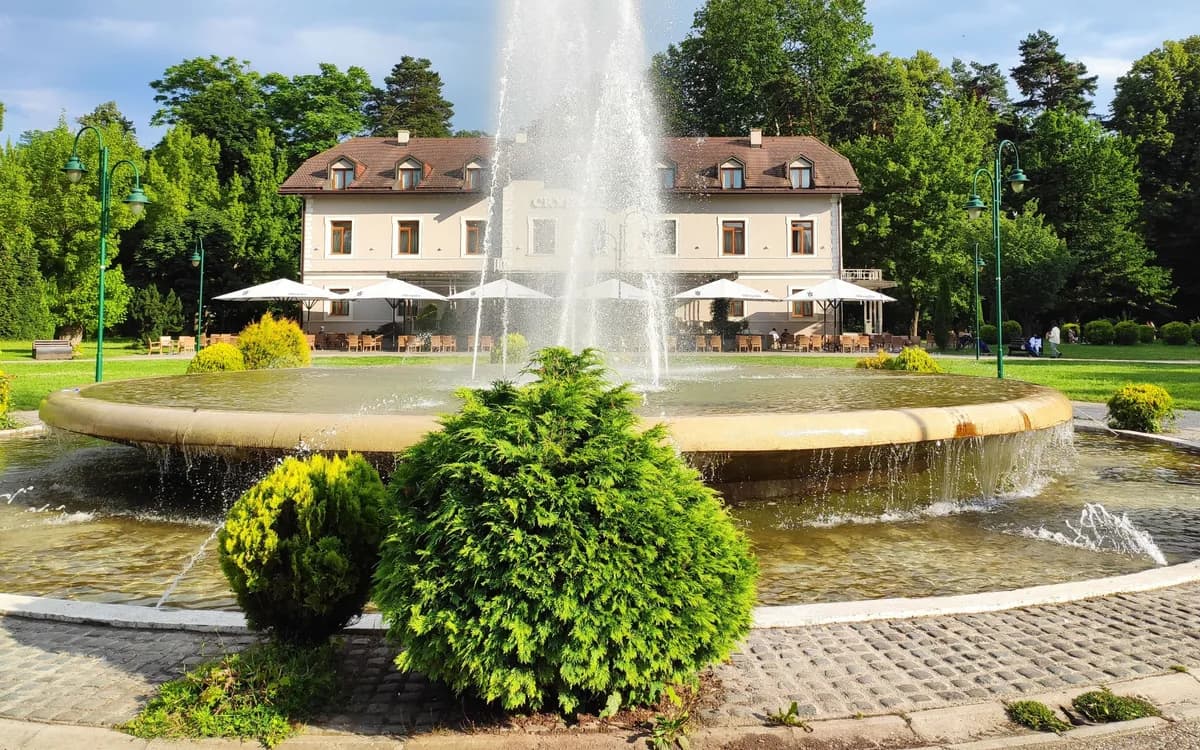 Actual Ilidža park fountain and historic-looking building in a landscaped setting, not the Thermal Riviera complex