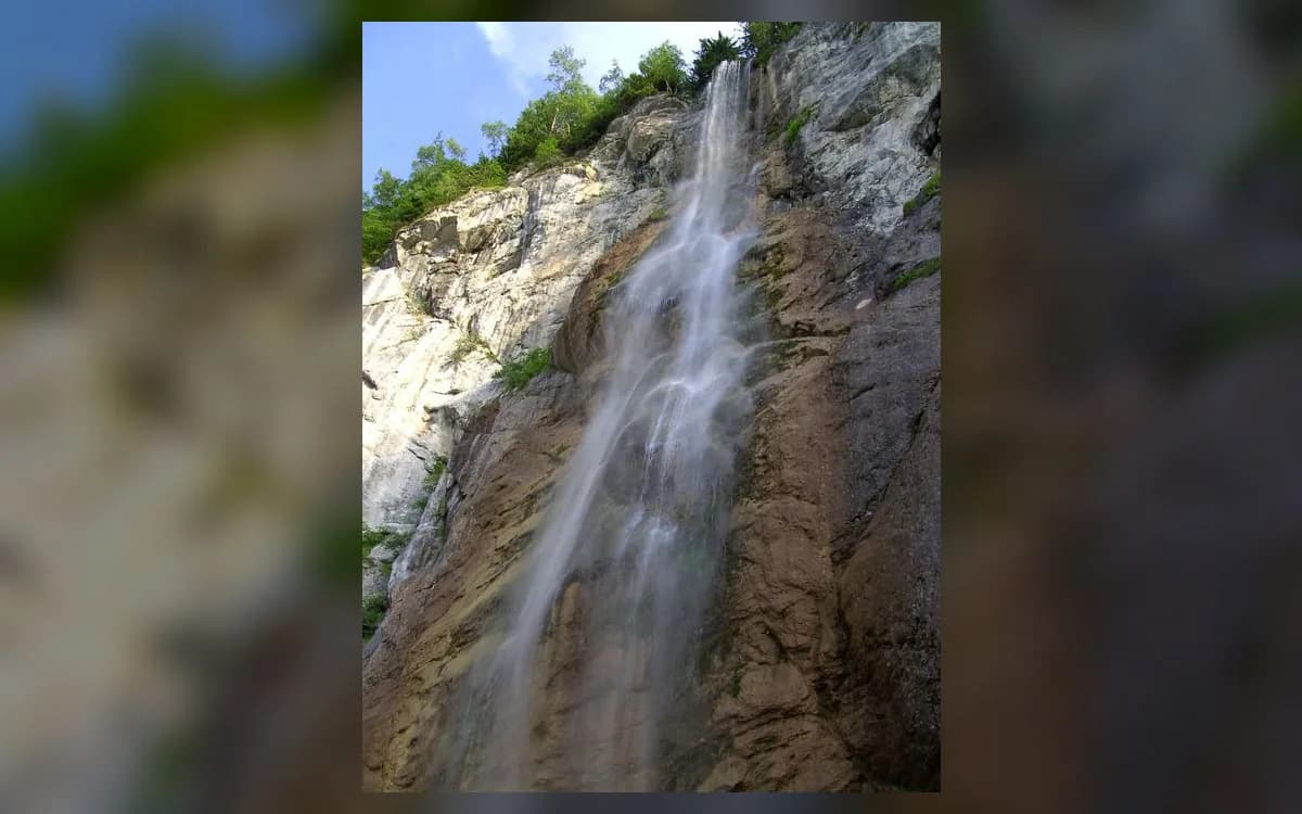 Skakavac waterfall cascading down a tall limestone cliff in the protected hills north of Sarajevo