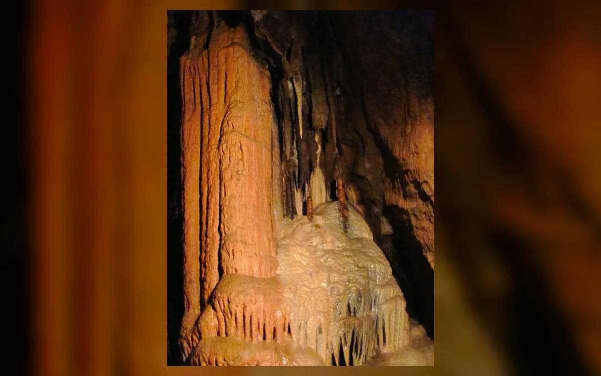 Illuminated stalagmite and flowstone formations inside Orlovača Cave near Pale